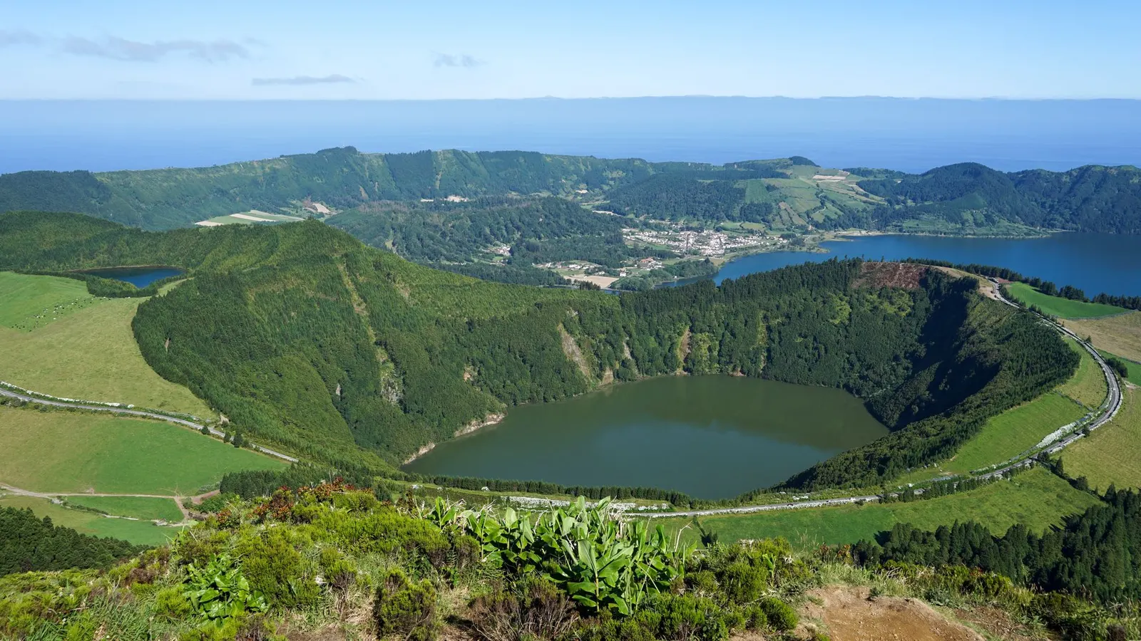Lagune volcanique verte des Açores sous un ciel changeant