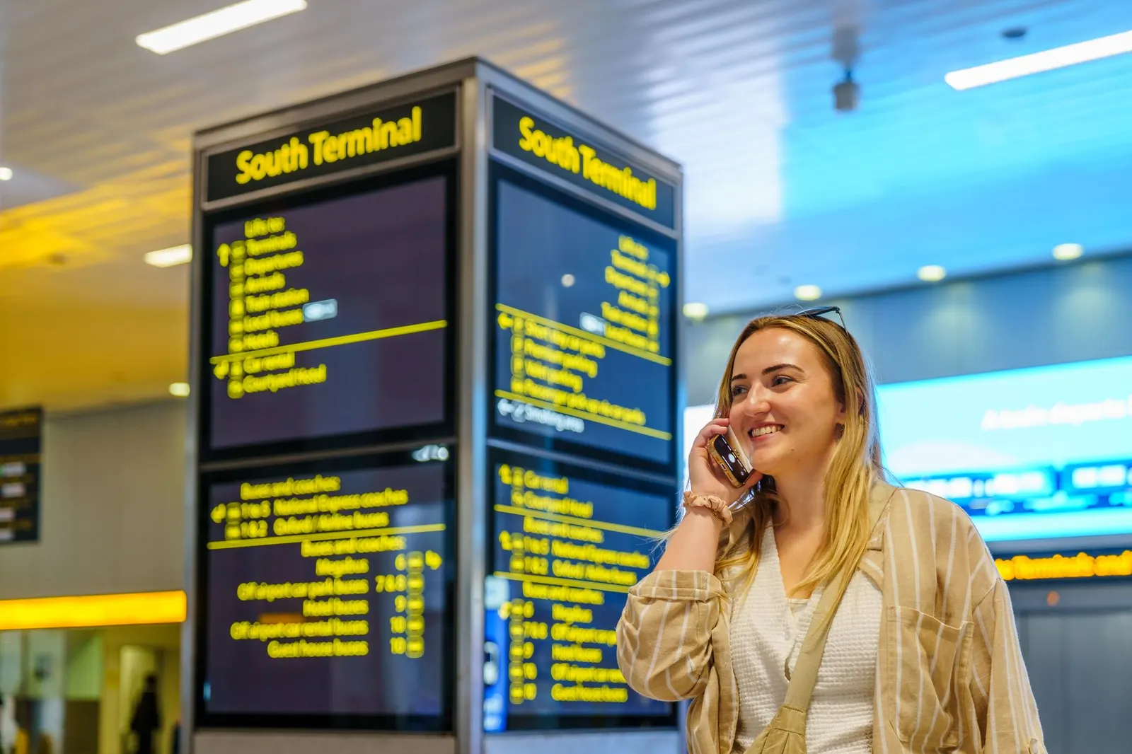 Voyageur consultant les horaires de vol dans un aéroport lumineux