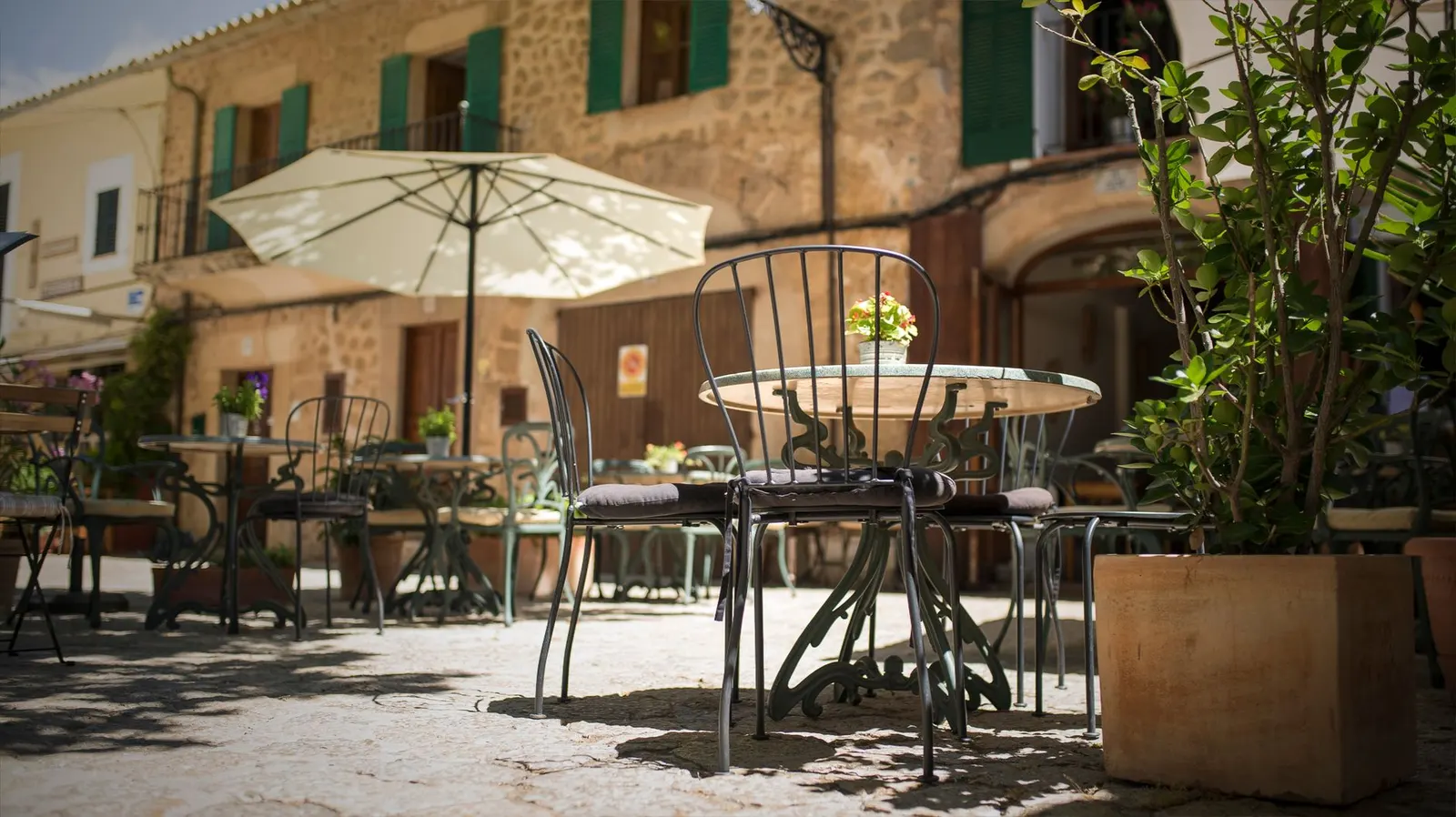Voyageur attablé à une terrasse, prenant le temps d’observer une rue