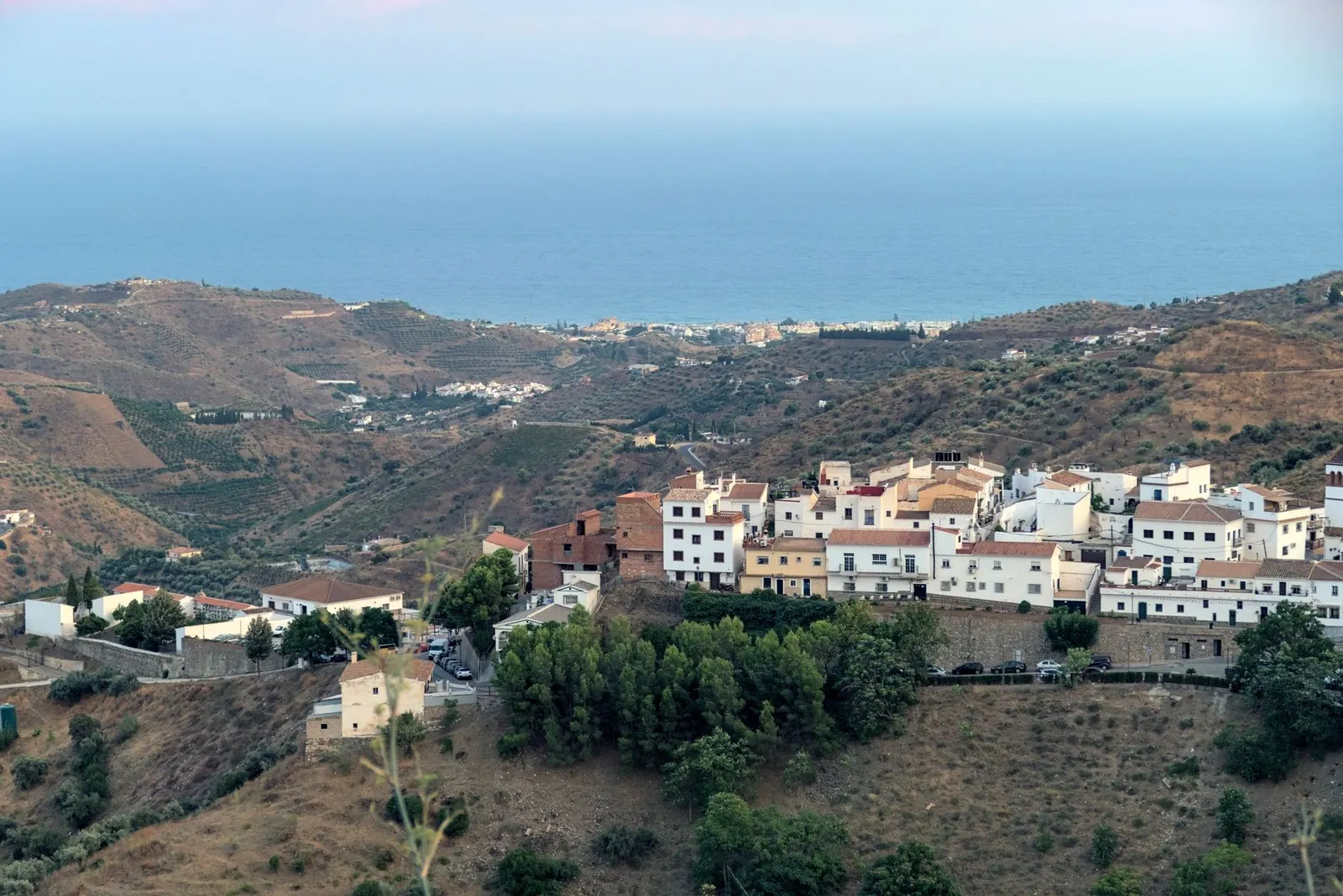Village blanc andalou accroché à flanc de colline sous le soleil